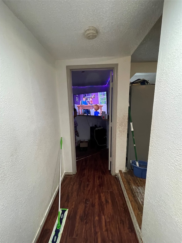 hallway with hardwood / wood-style flooring and a textured ceiling