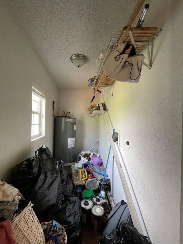 miscellaneous room with a textured ceiling and electric water heater