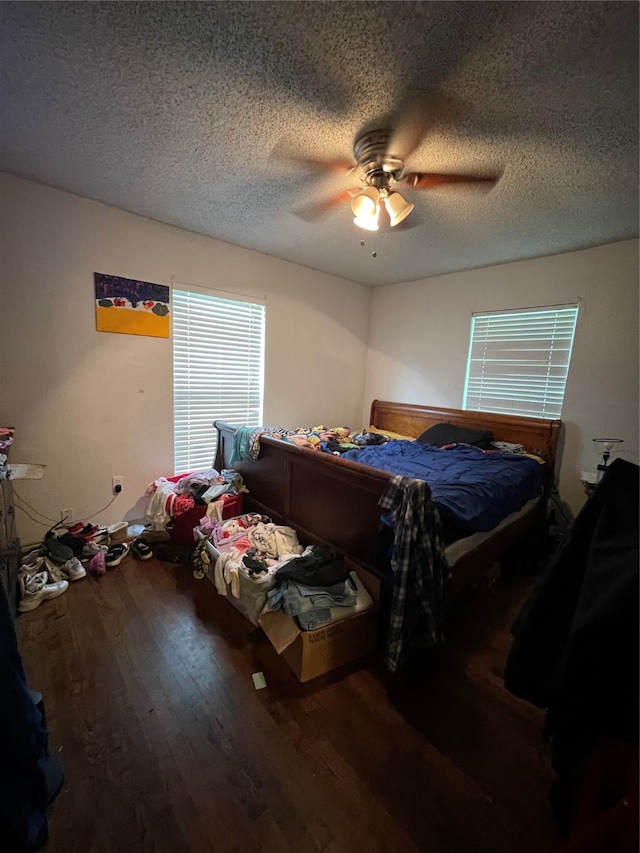 bedroom featuring hardwood / wood-style floors, ceiling fan, and a textured ceiling