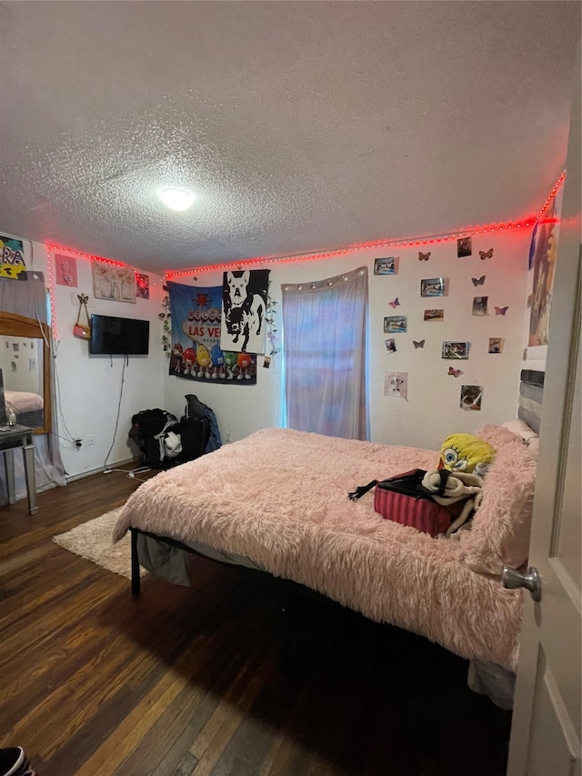 bedroom with a textured ceiling and dark wood-type flooring