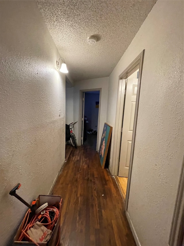 hallway featuring hardwood / wood-style floors and a textured ceiling