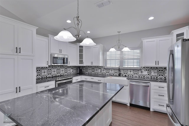 kitchen with backsplash, appliances with stainless steel finishes, sink, and dark hardwood / wood-style floors