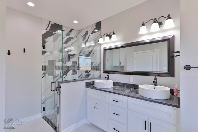 bathroom with a shower with door, tile flooring, vanity with extensive cabinet space, and double sink