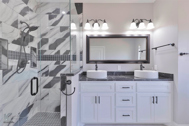 bathroom featuring dual vanity and a shower with door