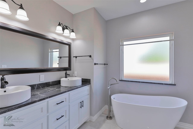 bathroom featuring a tub, dual vanity, and tile floors