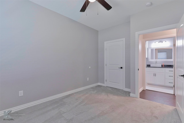 unfurnished bedroom featuring wood-type flooring, sink, and ceiling fan