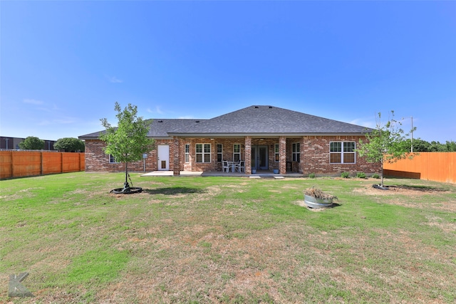 back of house featuring a patio area and a yard