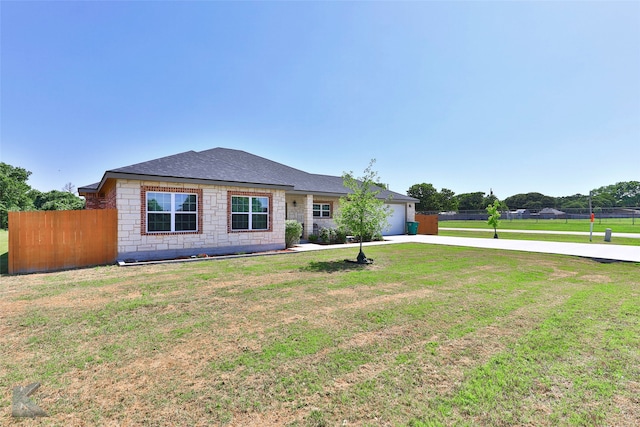 ranch-style house featuring a front lawn and a garage