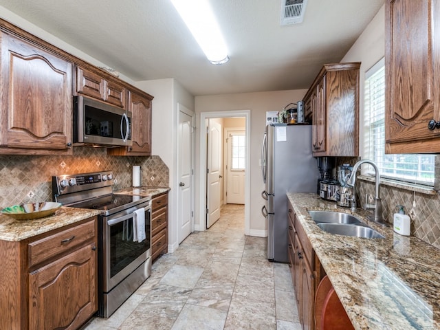 kitchen featuring sink, light tile floors, backsplash, and appliances with stainless steel finishes