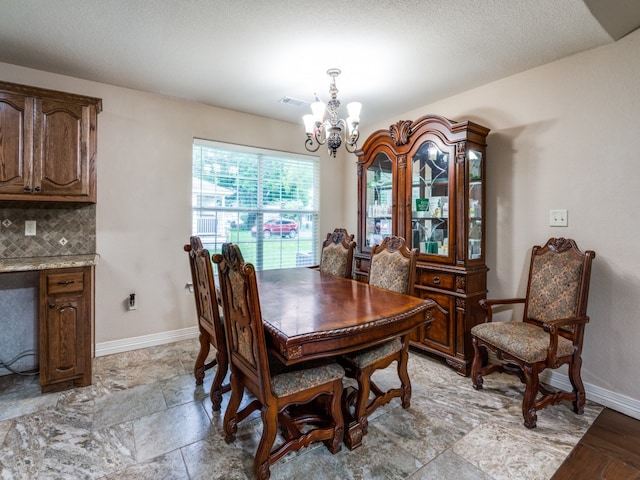 dining space featuring a notable chandelier, a textured ceiling, and light tile floors