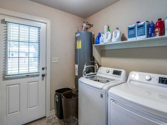 laundry room featuring water heater and independent washer and dryer