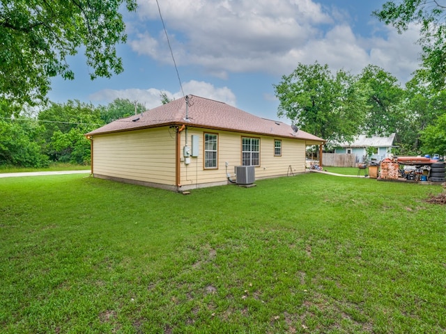 back of property featuring central AC and a yard