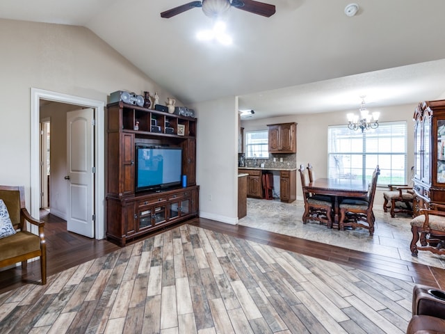 living room featuring ceiling fan with notable chandelier, hardwood / wood-style flooring, lofted ceiling, and sink