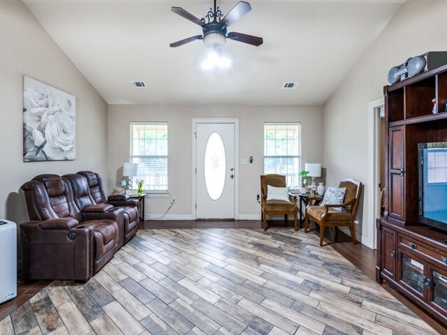 living room with a wealth of natural light, wood-type flooring, and ceiling fan