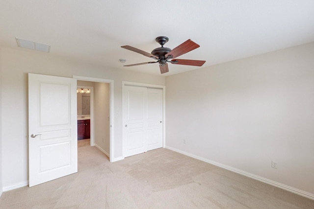 unfurnished bedroom with ceiling fan, light colored carpet, and a closet