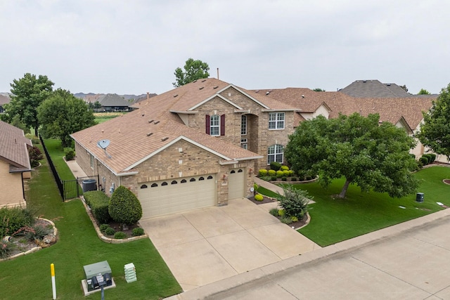 view of front facade with a garage, a front lawn, and central air condition unit