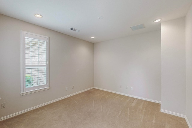 spare room featuring light colored carpet