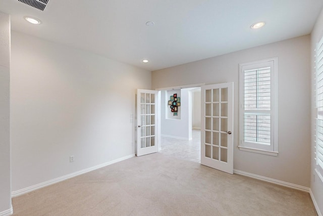 carpeted spare room with french doors