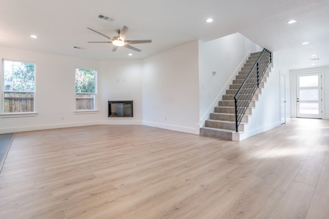 unfurnished living room featuring light hardwood / wood-style flooring and ceiling fan