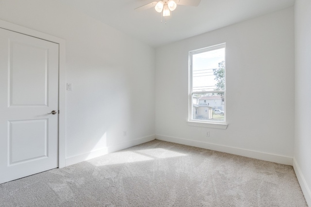 empty room with ceiling fan and carpet flooring