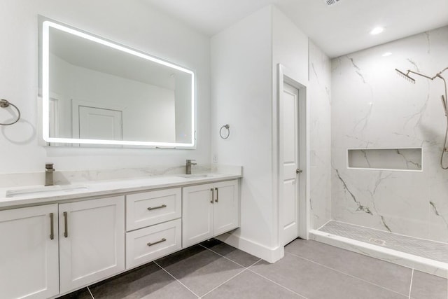 bathroom with vanity, tile patterned floors, and a tile shower