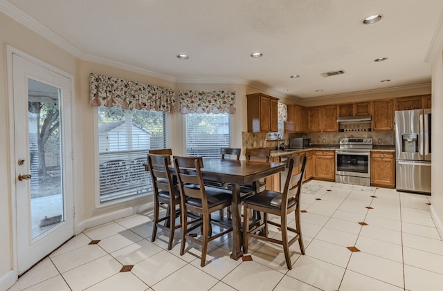 tiled dining room featuring a wealth of natural light, sink, and crown molding