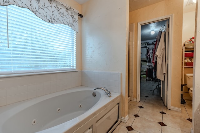 bathroom featuring tile patterned flooring, a bathtub, and toilet