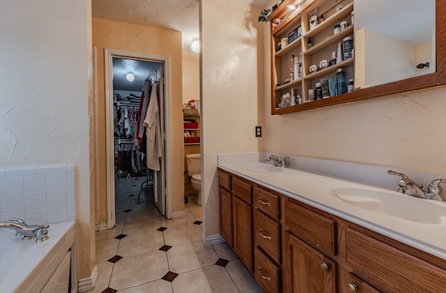 bathroom with vanity, tile patterned floors, toilet, and a bathing tub