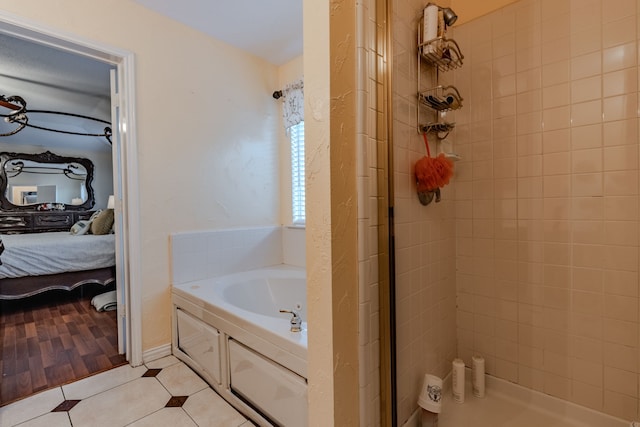 bathroom with independent shower and bath and hardwood / wood-style flooring