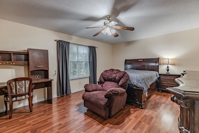 bedroom featuring dark wood-type flooring, ceiling fan, and a textured ceiling