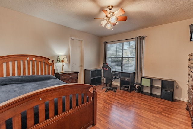 bedroom with a textured ceiling, light wood-type flooring, and ceiling fan