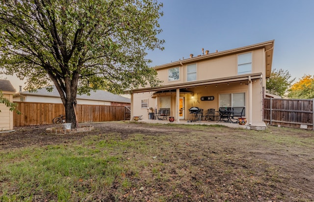 rear view of property with a lawn and a patio