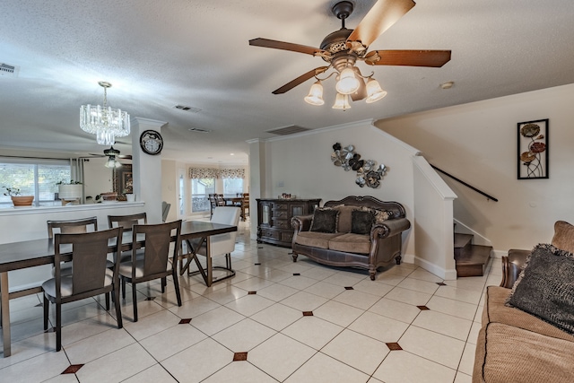 tiled living room with crown molding, a healthy amount of sunlight, and ceiling fan with notable chandelier