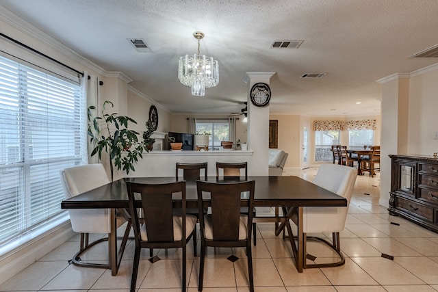 dining room with ornamental molding, light tile patterned flooring, a healthy amount of sunlight, and ceiling fan with notable chandelier