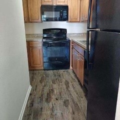 kitchen featuring black appliances and hardwood / wood-style flooring