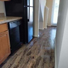 kitchen with black dishwasher and dark wood-type flooring