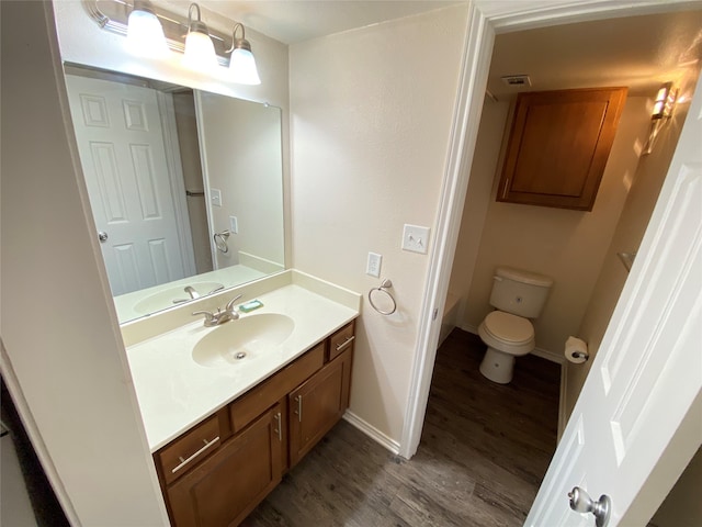 bathroom with hardwood / wood-style floors, vanity, and toilet