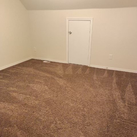 spare room featuring dark colored carpet