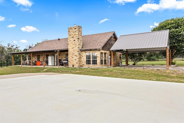 view of front of house featuring a patio area, a chimney, and a front lawn