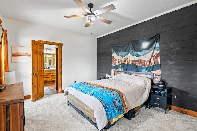 carpeted bedroom featuring wood walls and ceiling fan