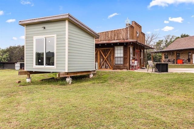 rear view of property with an outbuilding, a yard, and central AC unit