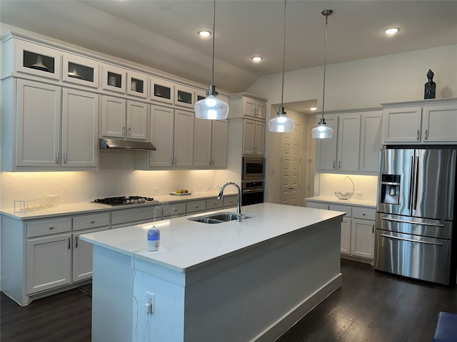 kitchen with stainless steel appliances, a kitchen island with sink, decorative light fixtures, sink, and tasteful backsplash