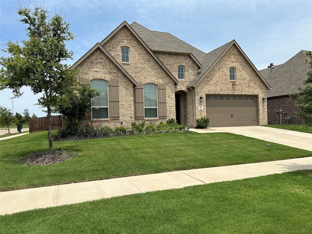 french provincial home featuring a front lawn and a garage