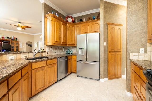 kitchen with stainless steel appliances, ceiling fan, crown molding, sink, and dark stone countertops