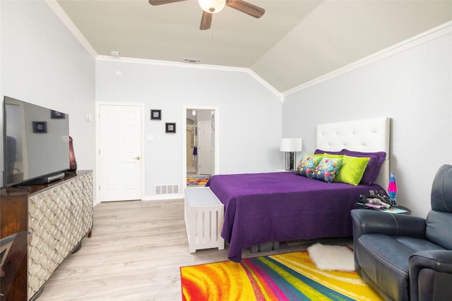 bedroom featuring ensuite bath, ceiling fan, light hardwood / wood-style flooring, vaulted ceiling, and ornamental molding