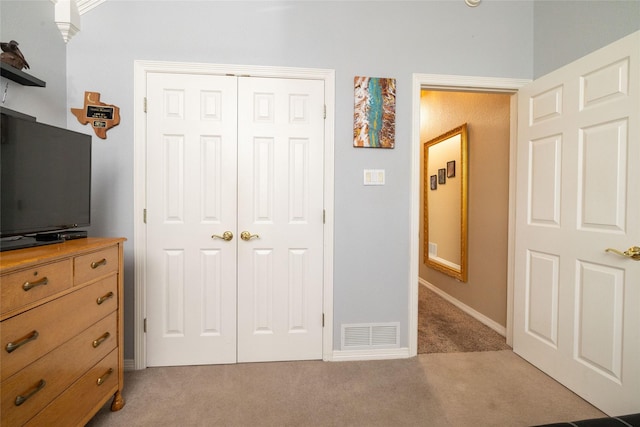 bedroom featuring light colored carpet and a closet