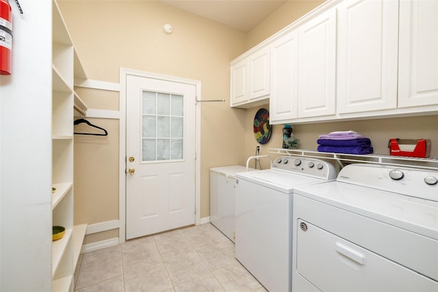 laundry room featuring washer and dryer, cabinets, and light tile patterned floors