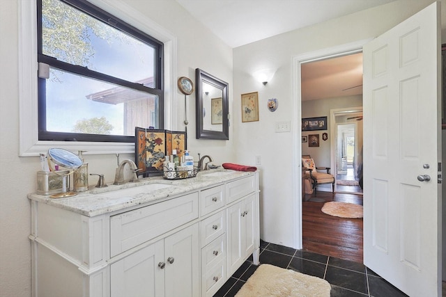 ensuite bathroom featuring tile patterned floors and double vanity