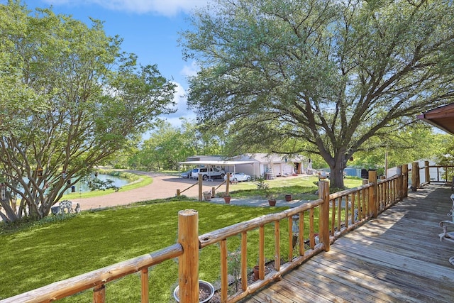 wooden terrace featuring a water view and a yard