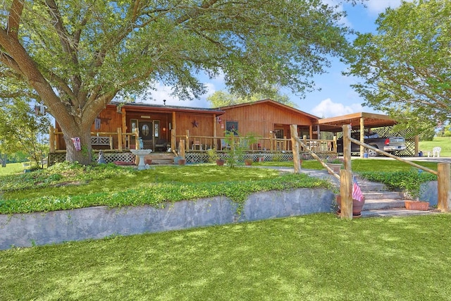 rear view of house with a lawn and covered porch